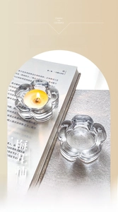 Macro detail of plum blossom glass candle holder with glowing tealight candle
