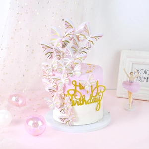 Detailed view of white gold-rimmed butterfly toppers and a Happy Birthday cake sign