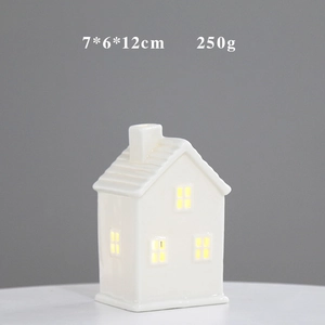 Detail of white ceramic house decor with warm LED light and 7x6x12cm dimensions