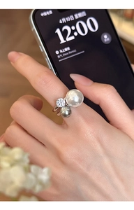 Close-up of elegant double pearl ring with zircon stone on model hand for daily styling