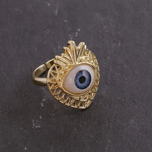 Detailed view of an 18K gold heart-shaped ring featuring a blue and white evil eye centerpiece