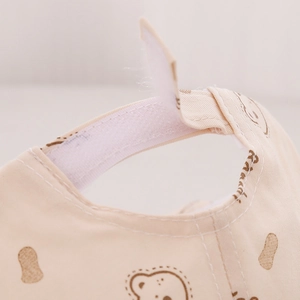 Close-up of baby bear print cap showing adjustable white Velcro strap and soft fabric