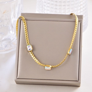 Detail of gold titanium chain necklace with three iridescent rectangular gemstones