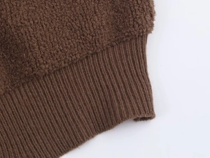 Detail of brown boucle fabric and ribbed knit cuffs on a warm autumn bomber jacket
