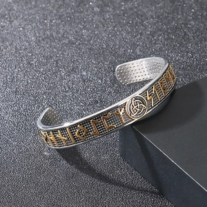 Detailed macro view of Viking rune engravings and Celtic knots on silver steel bracelet