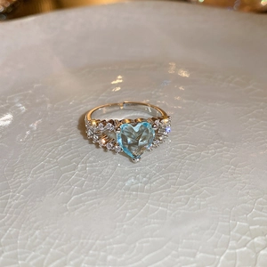 Macro shot of double-layer silver heart ring with blue zircon stones on ceramic