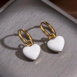 Minimalist gold hoop earrings with white heart pendant made of polished stainless steel