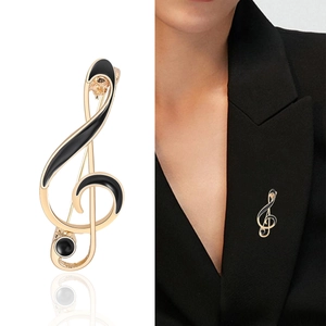 Elegant gold musical note brooch with black enamel and rhinestones on suit lapel