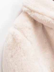 Macro shot of high-density soft cream faux fur texture on a French lapel coat