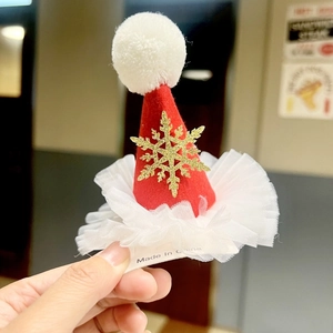 Detail of red velvet mini Santa hat hair clip with gold snowflake and mesh trim