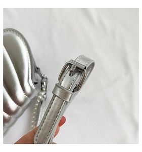 Nahaufnahme der silbernen Muscheltasche mit polierter Metallschnalle und Glanzdetails