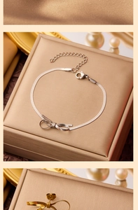 Détail du bracelet chaîne serpent argentée avec nœud et fermoir sur boîte cadeau
