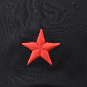 Détail de la broderie étoile rouge en 3D sur le tissu sergé de coton noir de la casquette