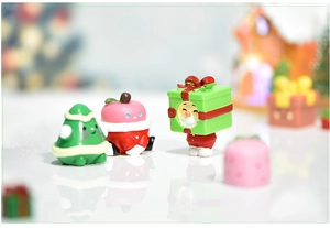 Macro shot of miniature Christmas tree and apple ornaments with warm festive lighting