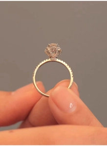 Detail view of flower-shaped rose gold ring with diamond and pave setting on the band