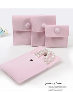 Detailed view of pink velvet jewelry pouches in three sizes with pearl necklace inside