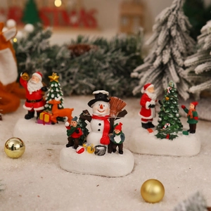 Detailed view of resin Christmas house figurines with Santa Claus and snowman motifs