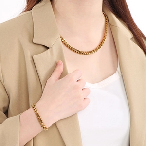 Close-up of a model wearing a premium gold-plated 9mm Cuban link chain and bracelet set