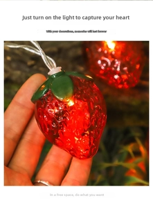 Vista macro di una ghirlanda LED a fragola con finitura rossa e luce calda interna