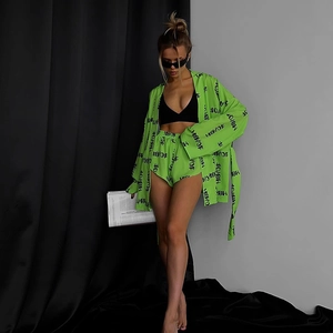 Detail of neon green pajama set with all-over black letter print and waist tie closure