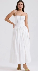 Detail view of white sundress with lace trim, waist-shaping design and pleated hem