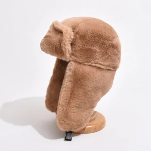Brown plush winter trapper hat with ear flaps and buckle closure on a wooden stand