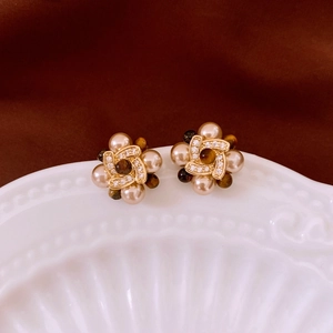 Macro shot of vintage gold flower earrings with pearls, brown gemstones, and zircons