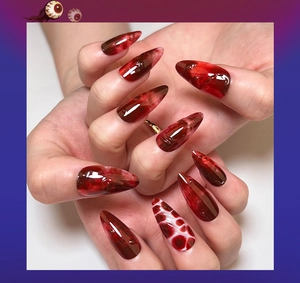 Detail of almond-shaped 3D blood marble nails with realistic red water drop decorations