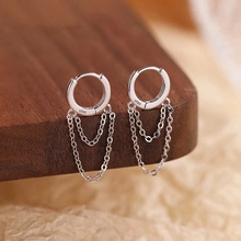 Makroansicht von S925 Sterling Silber Quastenkette Ohrringen auf strukturiertem Grund
