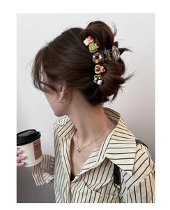 Detailed view of hair claw clip with cute 3D cartoon donut and cake dessert charms