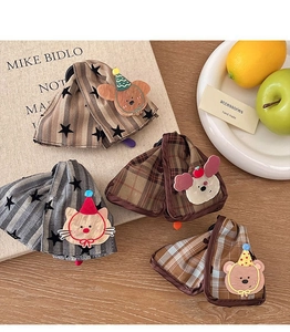 Detail view of cute animal hair clips featuring plaid and polka dot fabric textures