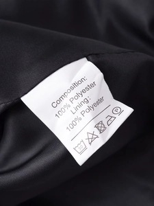 Detailed close-up of a garment care label showing 100% polyester fabric composition