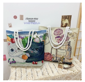 Detailed close-up of jacquard woven tote bags with cat and floral embroidery patterns