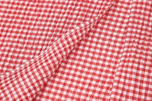 Macro detail of red and white seersucker fabric texture with classic plaid pattern