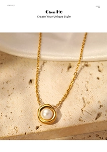 Detail of a gold pearl pendant necklace on beige travertine stone with white silk
