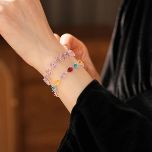 Close-up of multicolored oval-cut zircon bracelets with silver plating on a model wrist