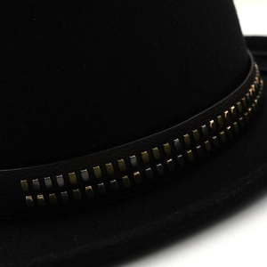 Detail of black felt top hat with studded leather band and vintage metallic rivets