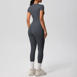 Detail view of seamless dark grey yoga set featuring high-waisted leggings and fitted shirt