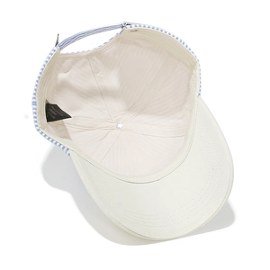 Detail of adjustable blue striped strap and metal buckle on cream cotton baseball cap