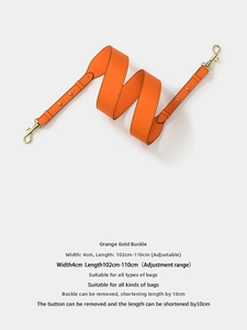 Detailed view of adjustable 4cm wide orange leather shoulder strap with gold buckles