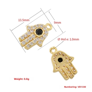 Macro detail of Hamsa Hand charm with micro-pave white zircon and black gemstone