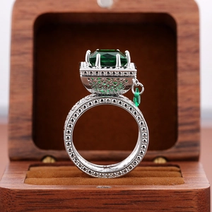 Macro view of emerald green gemstone ring with hollow carving in luxury jewelry box