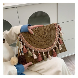 Detail of bohemian straw clutch with colorful tassels and hand-woven texture