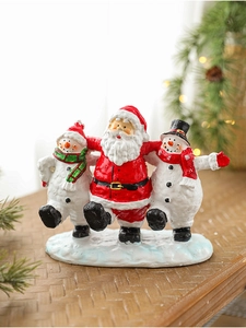 Close-up of resin Santa Claus and snowman figurines with cozy holiday background lighting