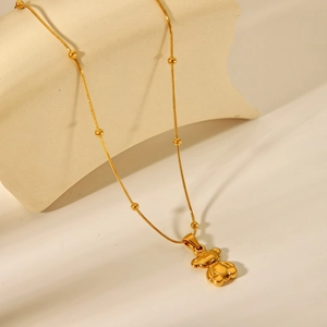 Detail of 18K gold plated bear pendant necklace with small beads on a minimalist chain