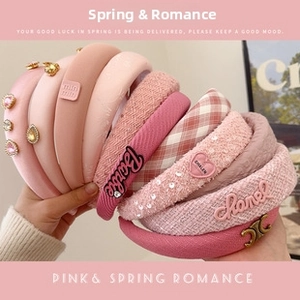 Detail of assorted pink plush and knitted headbands featuring elegant plaid and sequins