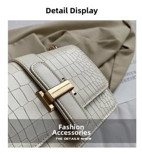 Detail shot of white crocodile embossed leather bag with premium gold metallic buckle