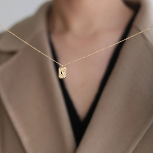 Élégant collier pendentif lune en plaqué or 18 carats au design minimaliste sur modèle