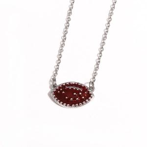 Detail of silver chain necklace with a red enamel American football pendant and silver studs