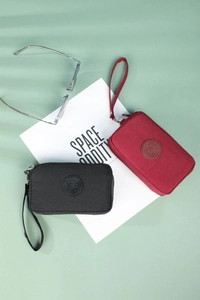 Close-up of black and dark red nylon mobile phone pouches with zipper and wrist strap